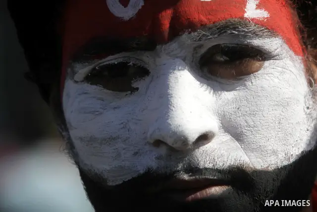 An Egyptian protester with his face painted in the colours of his national flag takes part in a protest demanding the army to hand power to civilians at Tahrir square in Cairo on January 27, 2012, a year after a popular...