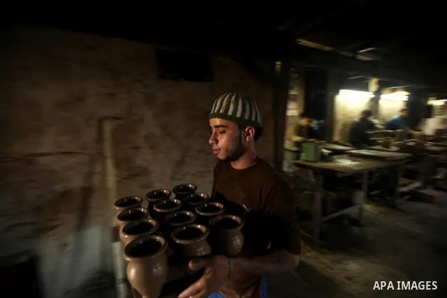 A Palestinian pottery workers spin a pot on a spin wheel at a pottery workshop in Gaza City on Jan 29. 2012. Pottery is a very ancient and traditional industry in Gaza City. Photo by Ashraf Amra. Photo by Ashraf Amra