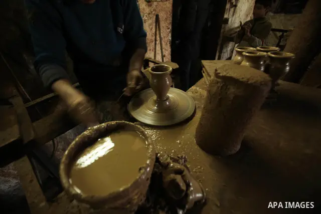A Palestinian pottery workers spin a pot on a spin wheel at a pottery workshop in Gaza City on Jan 29. 2012. Pottery is a very ancient and traditional industry in Gaza City. Photo by Ashraf Amra. Photo by Ashraf Amra