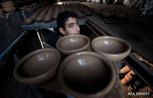 A Palestinian pottery workers spin a pot on a spin wheel at a pottery workshop in Gaza City on Jan 29. 2012. Pottery is a very ancient and traditional industry in Gaza City. Photo by Ashraf Amra. Photo by Ashraf Amra