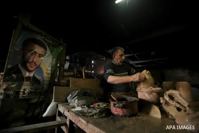 A Palestinian pottery workers spin a pot on a spin wheel at a pottery workshop in Gaza City on Jan 29. 2012. Pottery is a very ancient and traditional industry in Gaza City. Photo by Ashraf Amra. Photo by Ashraf Amra