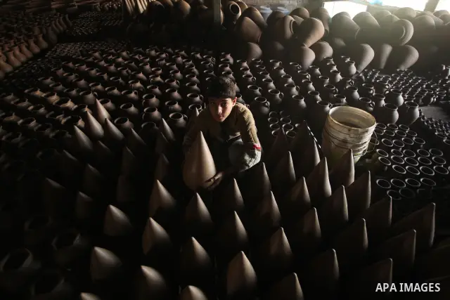 A Palestinian boy is standing in the middle of the earthenware vases at a pottery workshop in Gaza City on Jan 29. 2012. Pottery is a very ancient and traditional industry in Gaza City. Photo by Ashraf Amra