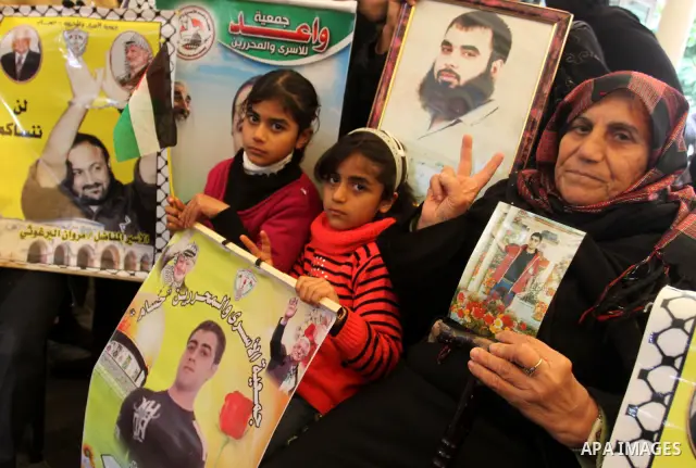 Palestinians hold pictures of their prisoned relatives in Israeli jails as they gather in a weekly activity calling for their liberty at the Red Cross headquarters in Gaza City, on Jan. 30, 2012. Photo by Mohammed Asad