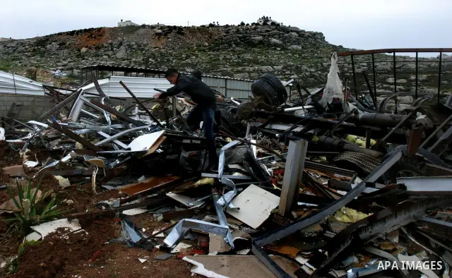 A Palestinian boy inspects the rubble of a home after it was demolished by Israeli bulldozers in the Arab east Jerusalem neighbourhood of Beit Hanina on January 30, 2012. Israel regularly demolishes homes in Arab east Je...