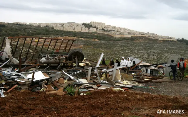 A Palestinian woman inspects the rubble of a home after it was demolished by Israeli bulldozers in the Arab east Jerusalem neighbourhood of Beit Hanina on January 30, 2012. Israel regularly demolishes homes in Arab east...