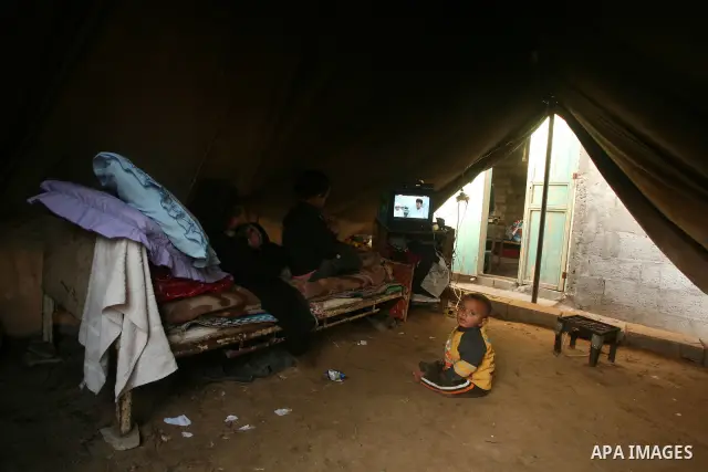 Palestinian children, from a Bedouin family,watch TV during low winter temperatures inside their family's tent in Gaza's Zeitoun neighbourhood January 31, 2012. Photo by Mahmud Nassar