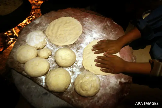 A Palestinian woman, from a Bedouin family, sits with her children preparing food during low winter temperatures inside her family's tent in Gaza's Zeitoun neighbourhood January 31, 2012. Photo by Mahmud Nassar