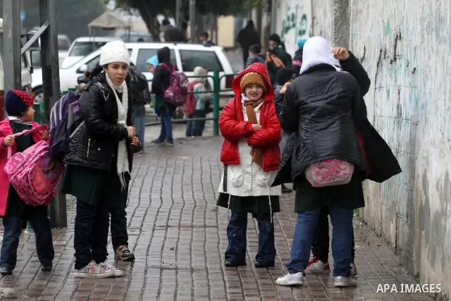 Palestinian students stand in a street during the heavy rain of the winter, in the Gaza City, Feb. 01, 2012. Photo by Mohammed Asad
