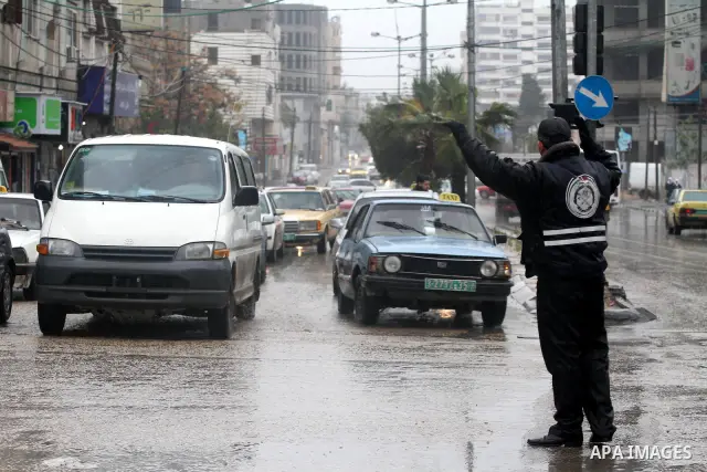Palestinian policemen organize the traffic during the heavy rain of the winter, in the Gaza City, Feb. 01, 2012. Photo by Mohammed Asad