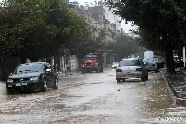 Palestinians drive their cars through a flooded street after heavy rain and cold winds, in the Gaza City, Feb. 01, 2012. Photo by Mohammed Asad
