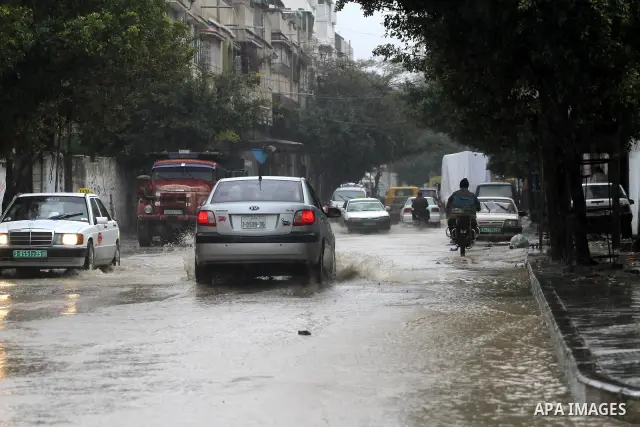 Palestinians drive their cars through a flooded street after heavy rain and cold winds, in the Gaza City, Feb. 01, 2012. Photo by Mohammed Asad