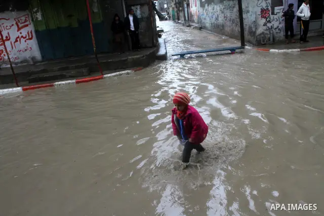 Palestinians walk in a street during the heavy rain of the winter, in the Gaza City, Feb. 01, 2012. Photo by Ashraf Amra
