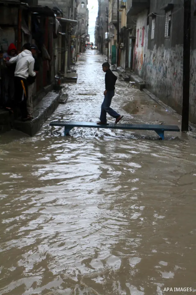 Palestinians walk in a street during the heavy rain of the winter, in the Gaza City, Feb. 01, 2012. Photo by Ashraf Amra
