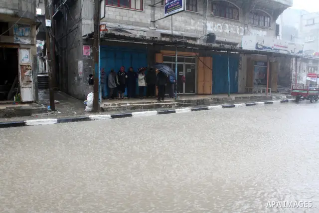 Palestinians walk in a street during the heavy rain of the winter, in the Gaza City, Feb. 01, 2012. Photo by Ashraf Amra