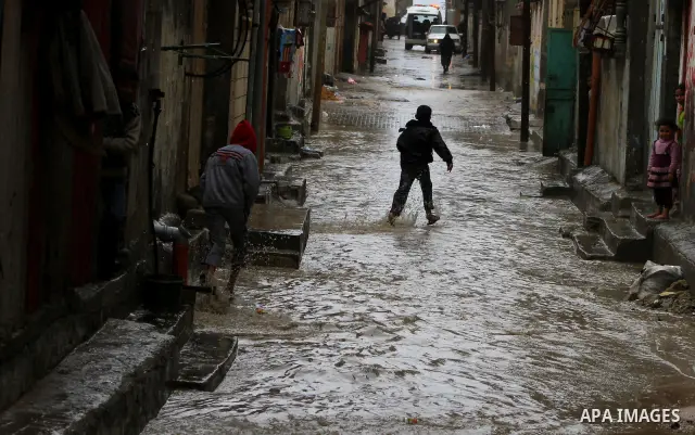 Palestinians walk in a street during the heavy rain of the winter, in the Gaza City, Feb. 01, 2012. Photo by Ashraf Amra
