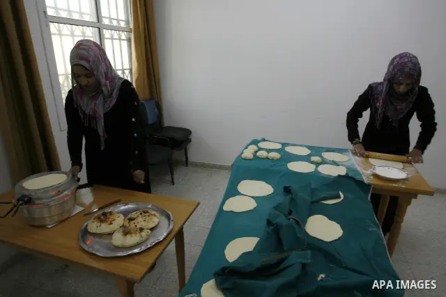 A Palestinian family prepares Bread traditional from Potatoes, at their house in town of Khan Yunis, southern Gaza Strip on February 2, 2012. Palestinian families used some of the manufacture of potato bread instead of t...