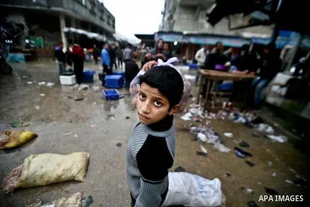 Palestinian children play in front of shop at the old Fras market during the heavy rain of the winter in Gaza city on Feb. 02, 2012. Photo by Ali Jadallah