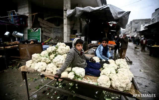Palestinian children play in front of shop at the old Fras market during the heavy rain of the winter in Gaza city on Feb. 02, 2012. Photo by Ali Jadallah