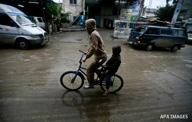 Palestinian children walk in a street during the heavy rain of the winter, in the Gaza City, Feb. 01, 2012. Photo by Ali Jadallah