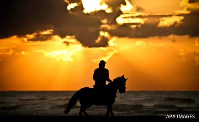 A Palestinian man is silhouetted against the setting sun as he rides a horses on a beach near Gaza City on a cold winter day's evening, on Feb. 02, 2012. Photo by Ali Jadallah