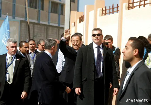 UN secretary general Ban Ki-moon waves during a visit to the construction site of a housing project in Khan Yunis in the southern Gaza Strip on February 2, 2012. Protesters threw shoes, sand and small stones at the convo...