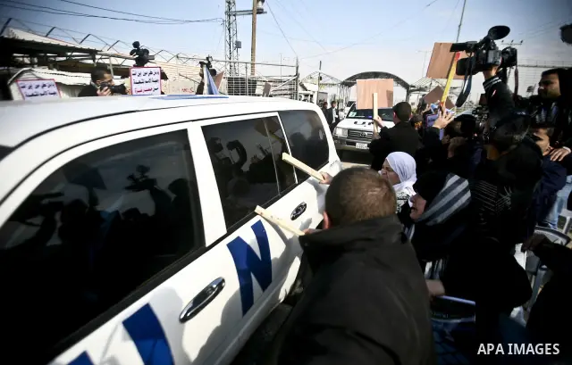 Relative of Palestinian prisoners in Israeli jails use wooden sticks to hit a vehicle in the convoy of UN Secretary-General Ban Ki-moon as it arrives at the Erez checkpoint in the northern Gaza Strip on February 2, 2012....