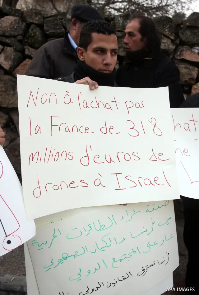 Palestinians hold banners during a demonstration in front of the French Cultural Center in the West Bank city of Ramallah on February 2, 2012, to protest against the drones deal that France intends to purchase from Israe...