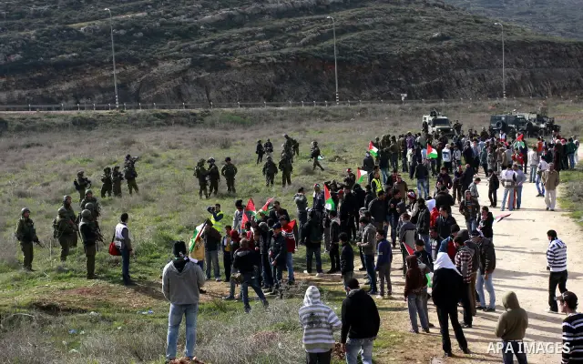 Palestinians holds national flag, during a protest in the Village Qaryut , near the Israeli settlement of Ali, in the northern West Bank, Friday, Feb. 03, 2012. Photo by Wagdi Eshtayah