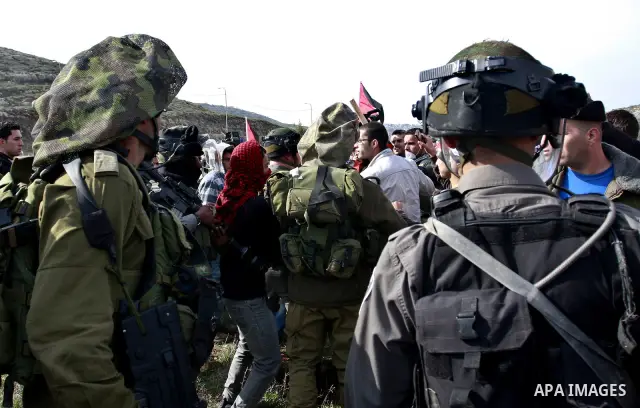 Israeli troops stop palestinian demonstrators during a protest in the Village Qaryut , near the Israeli settlement of Ali, in the northern West Bank, Friday, Feb. 03, 2012. Photo by Wagdi Eshtayah