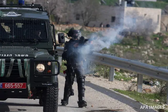 Israeli troops fire tear gas grenades at Palestinian protesters during a weekly protest against the Jewish settlement in the West Bank village of Nabi Saleh near Ramallah on February 3, 2012. Photo by Issam Rimawi