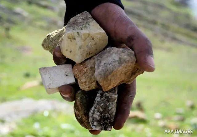A Palestinian youth hurls stones at Israeli troops during a weekly protest against the construction of Israel's controversial separation barrier and the expansion of Jewish settlements in the West Bank village of Nabi Sa...