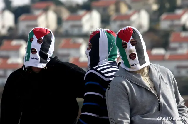 Palestinian demonstrators take a break during clashes with Israeli soldiers during a protest against the expansion of the nearby Jewish settlement of Halamish in the West Bank village of Nabi Saleh, near Ramallah, Friday...