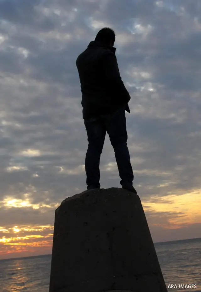 A Palestinian man is silhouetted against the setting sun on a cold winter day's evening, on Feb. 04, 2012. Photo by Mohammed Asad