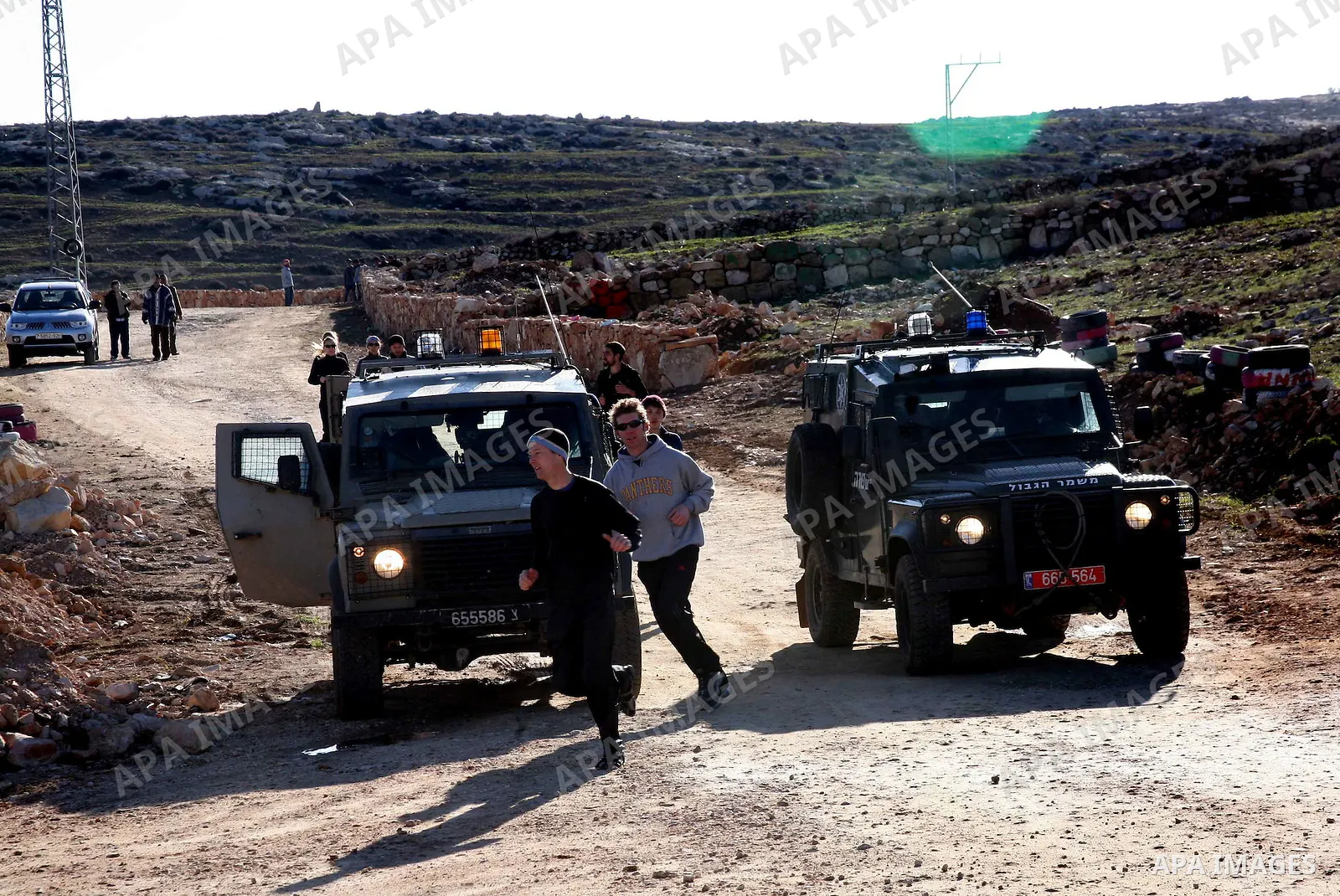 Israeli soldiers block the road in front of Palestinians, Israeli and foreign activists during a marathon to support the farmers and land owners in the West Bank city of Hebron on Feb. 4,2012. Israeli troops detained a P...