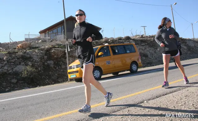 Palestinians, Israeli and foreign activists run during a marathon to support the farmers and land owners in the West Bank city of Hebron on Feb. 4,2012. Israeli troops detained a Palestinian and two foreign activists . P...