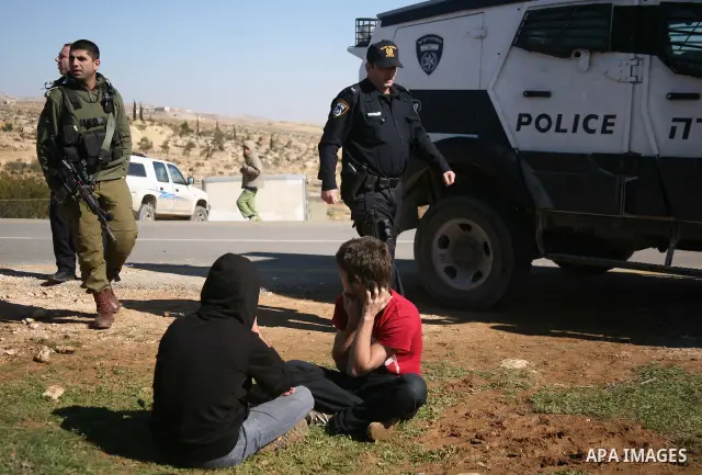 Israeli soldiers block the road in front of Palestinians, Israeli and foreign activists during a marathon to support the farmers and land owners in the West Bank city of Hebron on Feb. 4,2012. Israeli troops detained a P...