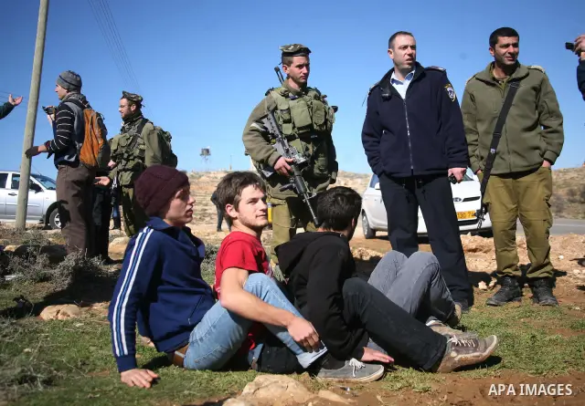 Israeli soldiers block the road in front of Palestinians, Israeli and foreign activists during a marathon to support the farmers and land owners in the West Bank city of Hebron on Feb. 4,2012. Israeli troops detained a P...