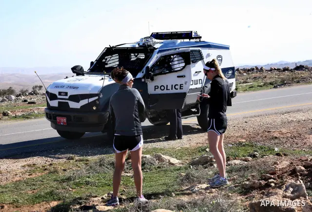 Israeli soldiers block the road in front of Palestinians, Israeli and foreign activists during a marathon to support the farmers and land owners in the West Bank city of Hebron on Feb. 4,2012. Israeli troops detained a P...