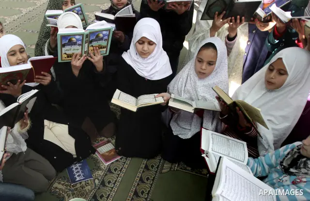 Palestinian Muslim girls read the Quran, as they celebrate the Prophet Muhammad's birthday at a mosque in the Balata refugee camp in the West Bank city of Nablus . Saturday, Feb. 4, 2012. Photo by Wagdi Eshtayah