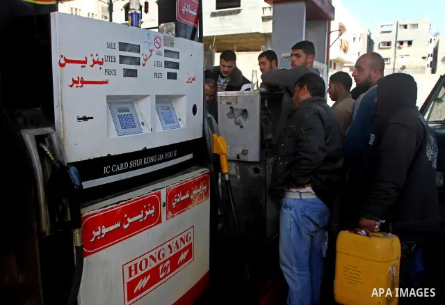 Palestinians wait to fill petrol in containers at a petrol station as a response to the rising price of gasoline in Gaza Strip, on Feb. 05, 2012. Photo by Ashraf Amra