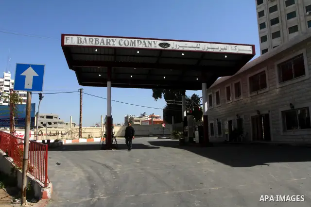A Palestinian stands a closed petrol station as a response to the rising price of gasoline in Gaza Strip, on Feb. 05, 2012. Photo by Ashraf Amra