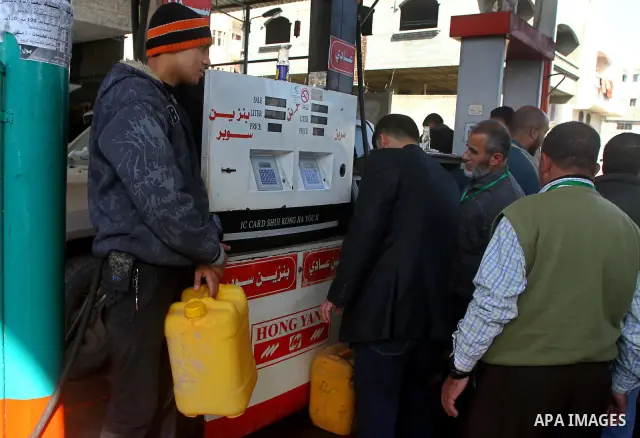 Palestinians wait to fill petrol in containers at a petrol station as a response to the rising price of gasoline in Gaza Strip, on Feb. 05, 2012. Photo by Ashraf Amra