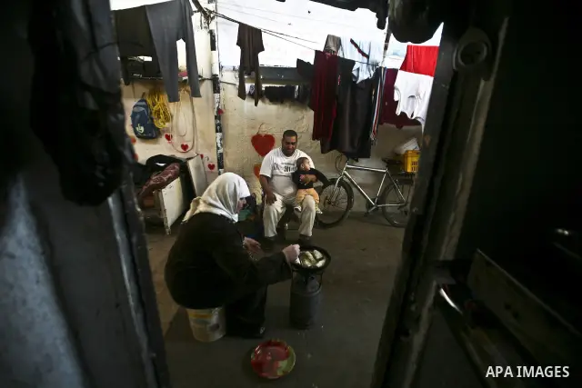 Palestinian refugee woman preparing food, sits with her family preparing food in the Jabaliya refugee camp in the northern area of the Gaza Strip on 05 February 2012. Photo by Ali Jadallah