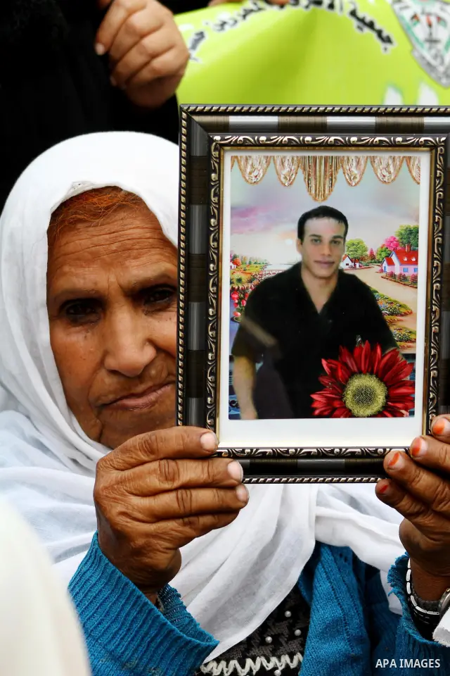 Palestinians hold pictures of their prisoned relatives in Israeli jails as they gather in a weekly activity calling for their liberty at the Red Cross headquarters. 6th February 2012. Photo by Ashraf Amra