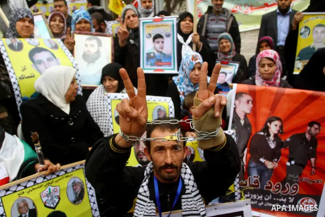 Palestinians hold pictures of their prisoned relatives in Israeli jails as they gather in a weekly activity calling for their liberty at the Red Cross headquarters. 6th February 2012. Photo by Ashraf Amra