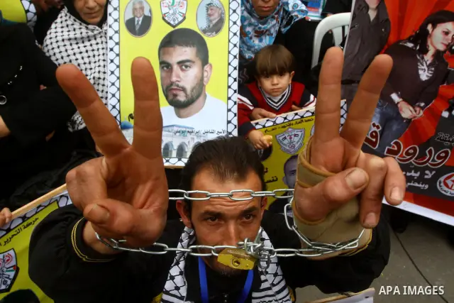 Palestinians hold pictures of their prisoned relatives in Israeli jails as they gather in a weekly activity calling for their liberty at the Red Cross headquarters. 6th February 2012. Photo by Ashraf Amra