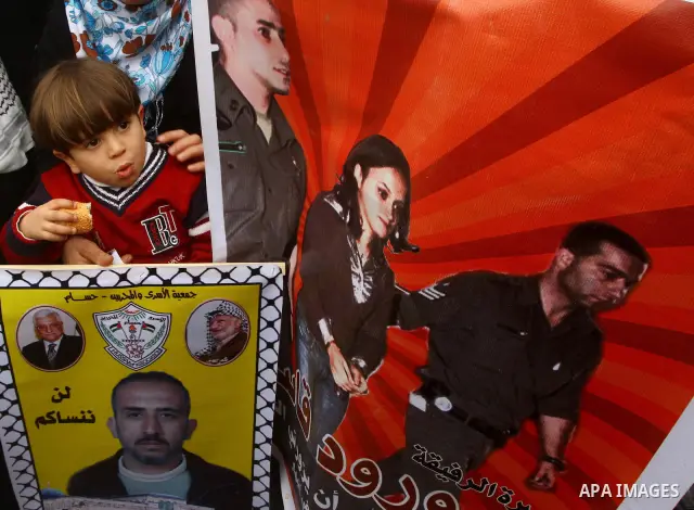 Palestinians hold pictures of their prisoned relatives in Israeli jails as they gather in a weekly activity calling for their liberty at the Red Cross headquarters. 6th February 2012. Photo by Ashraf Amra