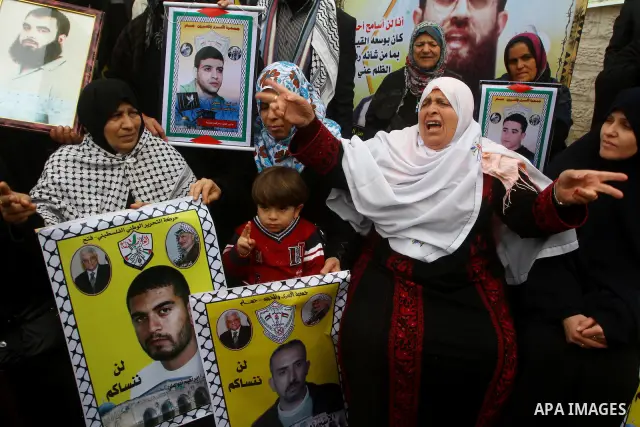 Palestinians hold pictures of their prisoned relatives in Israeli jails as they gather in a weekly activity calling for their liberty at the Red Cross headquarters. 6th February 2012. Photo by Ashraf Amra