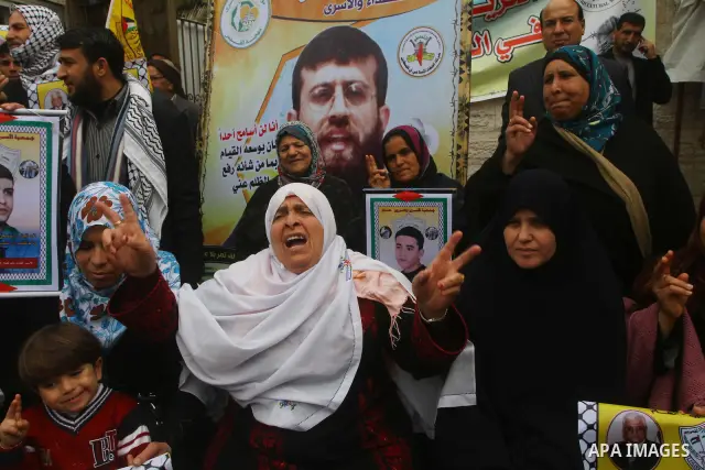 Palestinians hold pictures of their prisoned relatives in Israeli jails as they gather in a weekly activity calling for their liberty at the Red Cross headquarters. 6th February 2012. Photo by Ashraf Amra