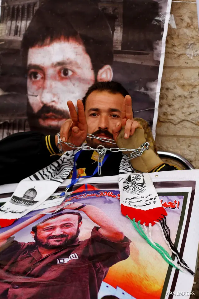 Palestinians hold pictures of their prisoned relatives in Israeli jails as they gather in a weekly activity calling for their liberty at the Red Cross headquarters. 6th February 2012. Photo by Ashraf Amra